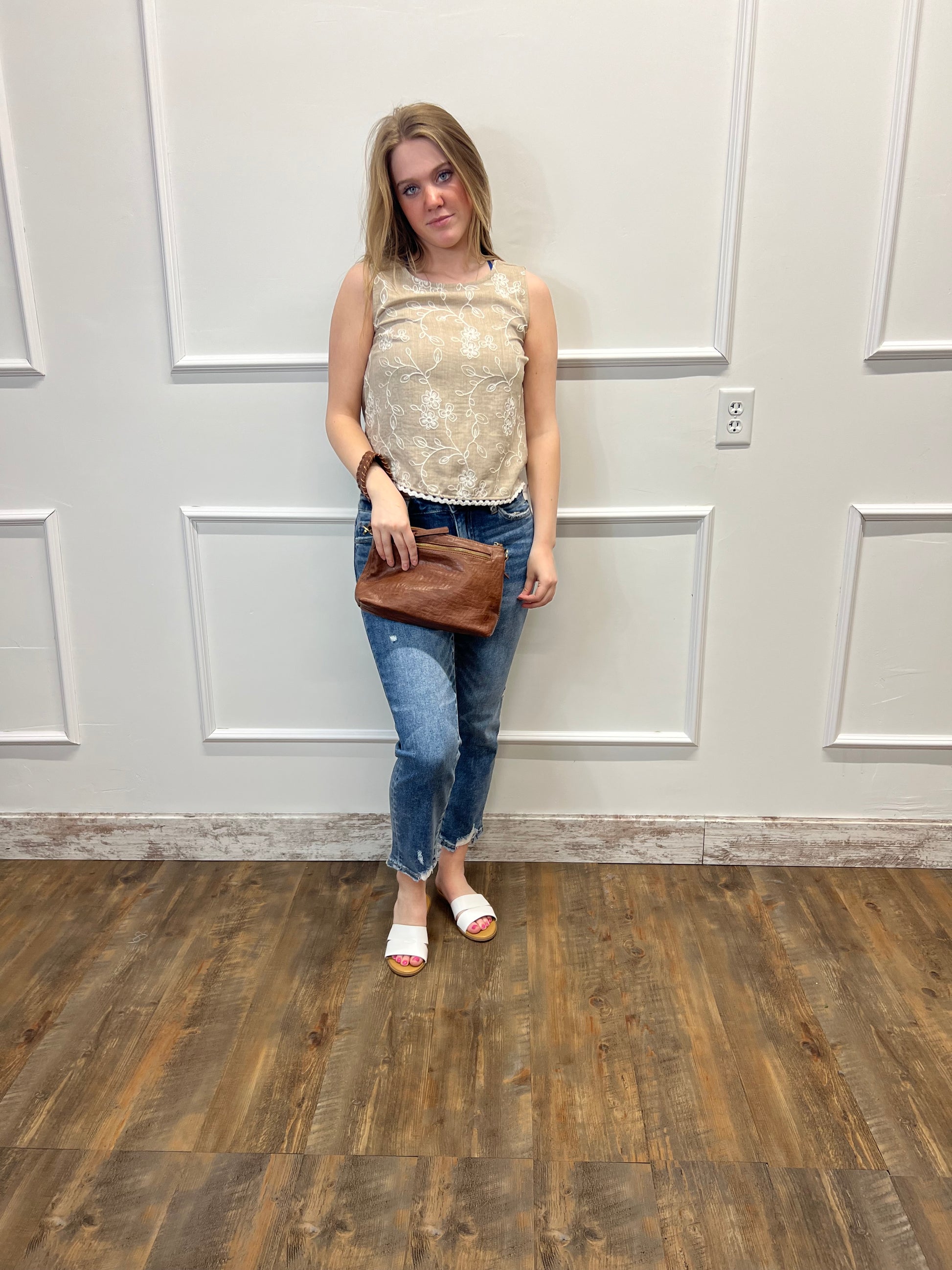 Person standing in a room with a white door and wooden floor.