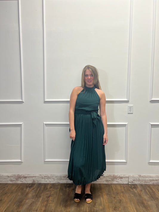 Woman in a green dress standing in front of a white door.