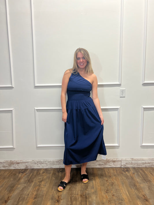 Woman in a blue dress standing in front of a white paneled door.