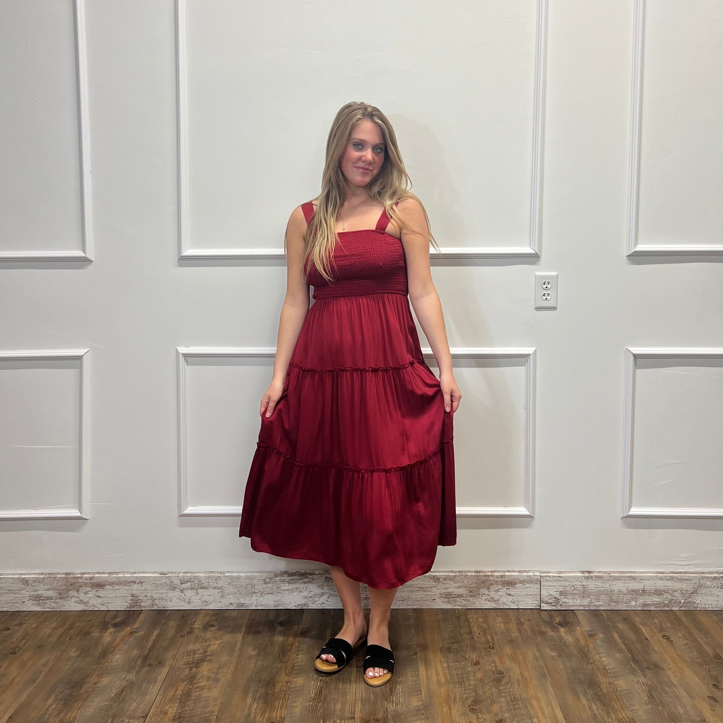 Woman in a red dress standing in front of a white paneled door.