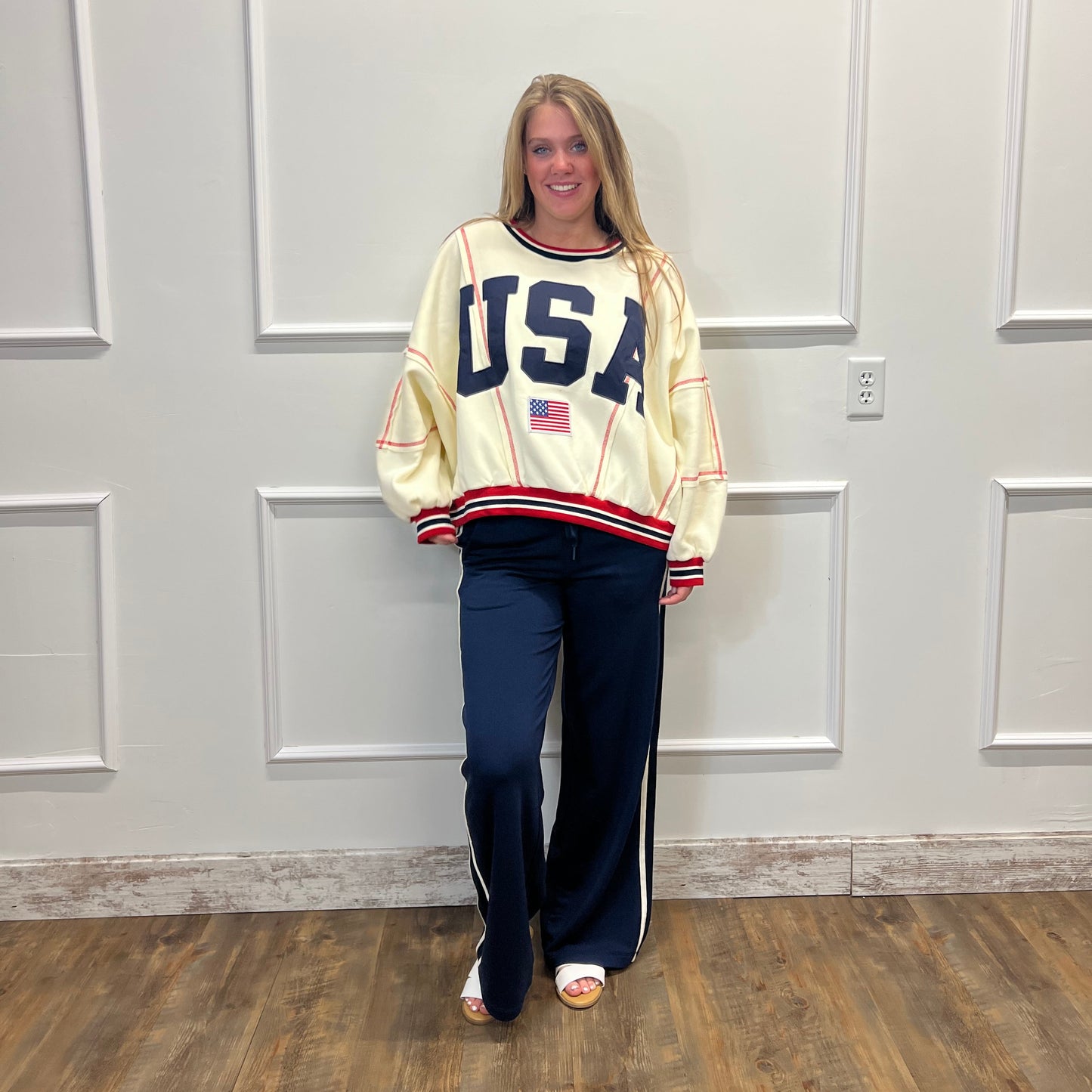 Person wearing a vintage-style jacket with 'USA' text in front of a white door.