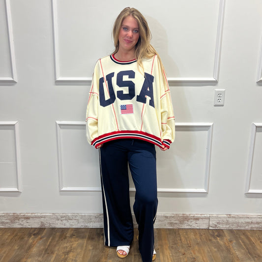 Person wearing a vintage-style 'USA' jersey standing in front of a white door.