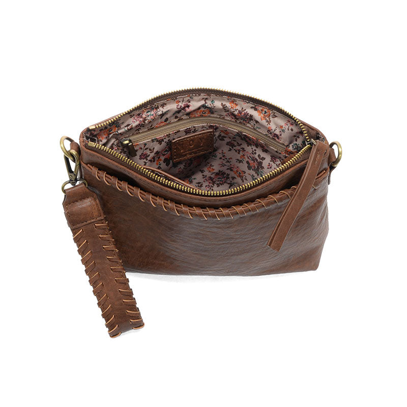 Brown leather handbag with floral interior on a white background