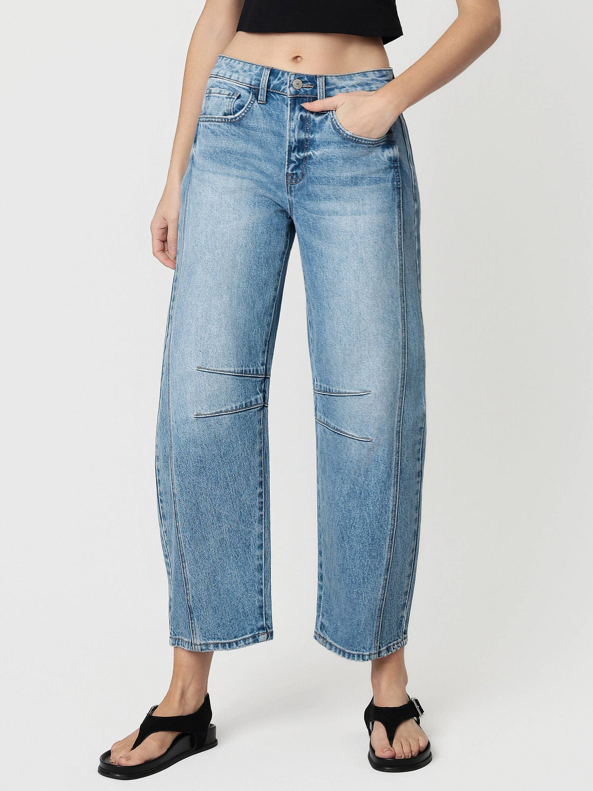 Person wearing light blue jeans on a white background