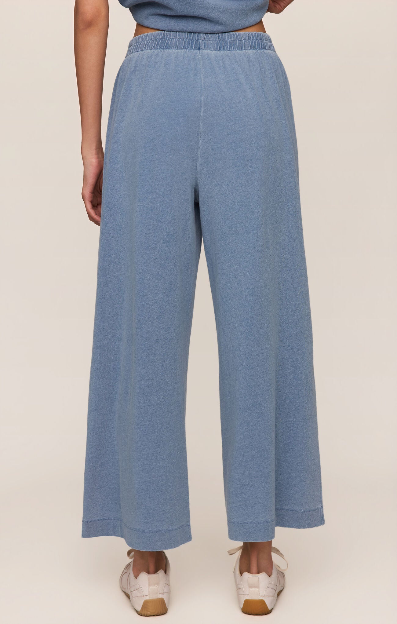 Blue pants worn by a person on a white background