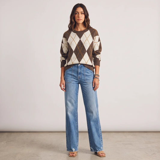 Model wearing Apricot Lane Duluth brown and cream argyle knit sweater with blue wide-leg denim jeans