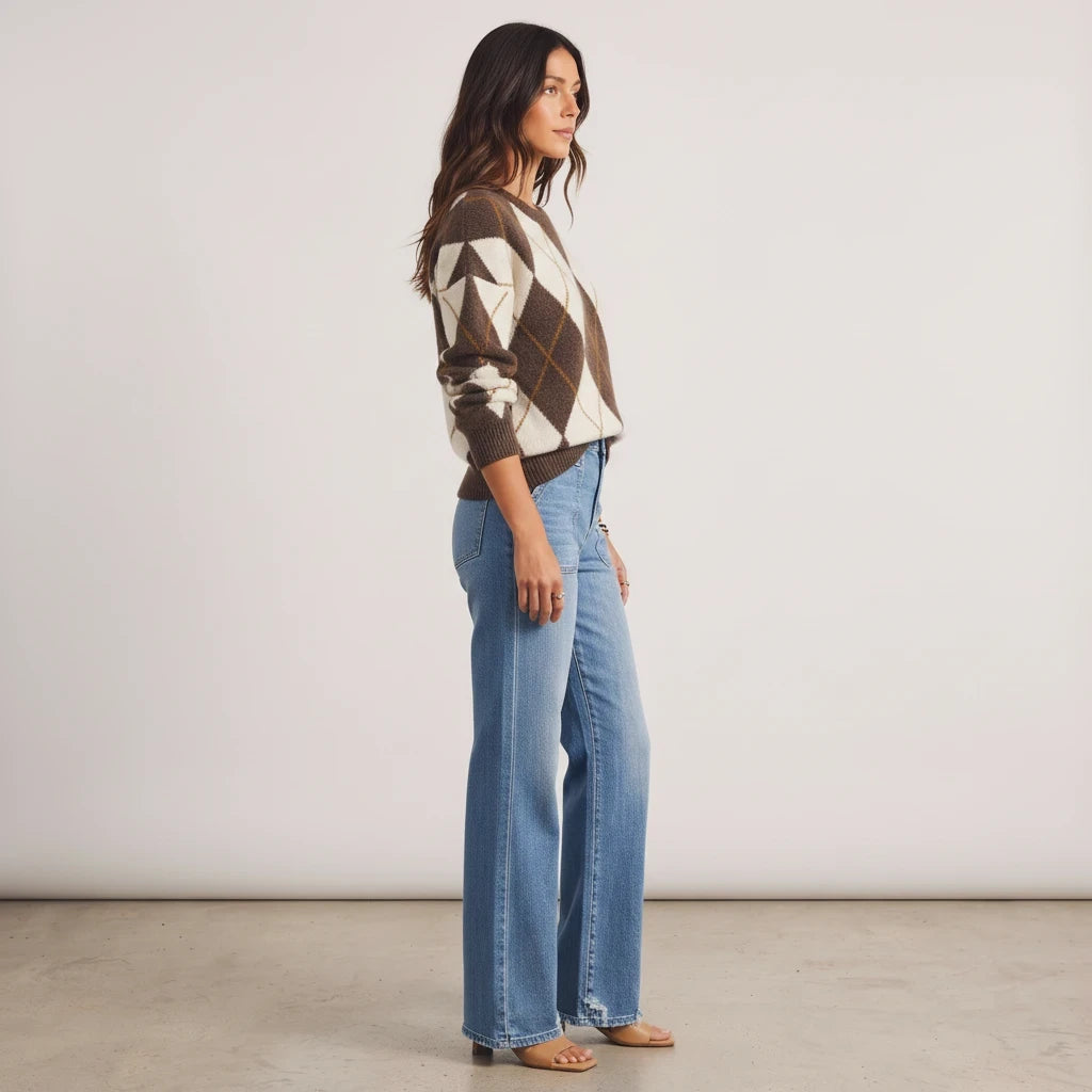 Model wearing an Apricot Lane Duluth brown and cream argyle knit sweater with light wash wide-leg denim jeans