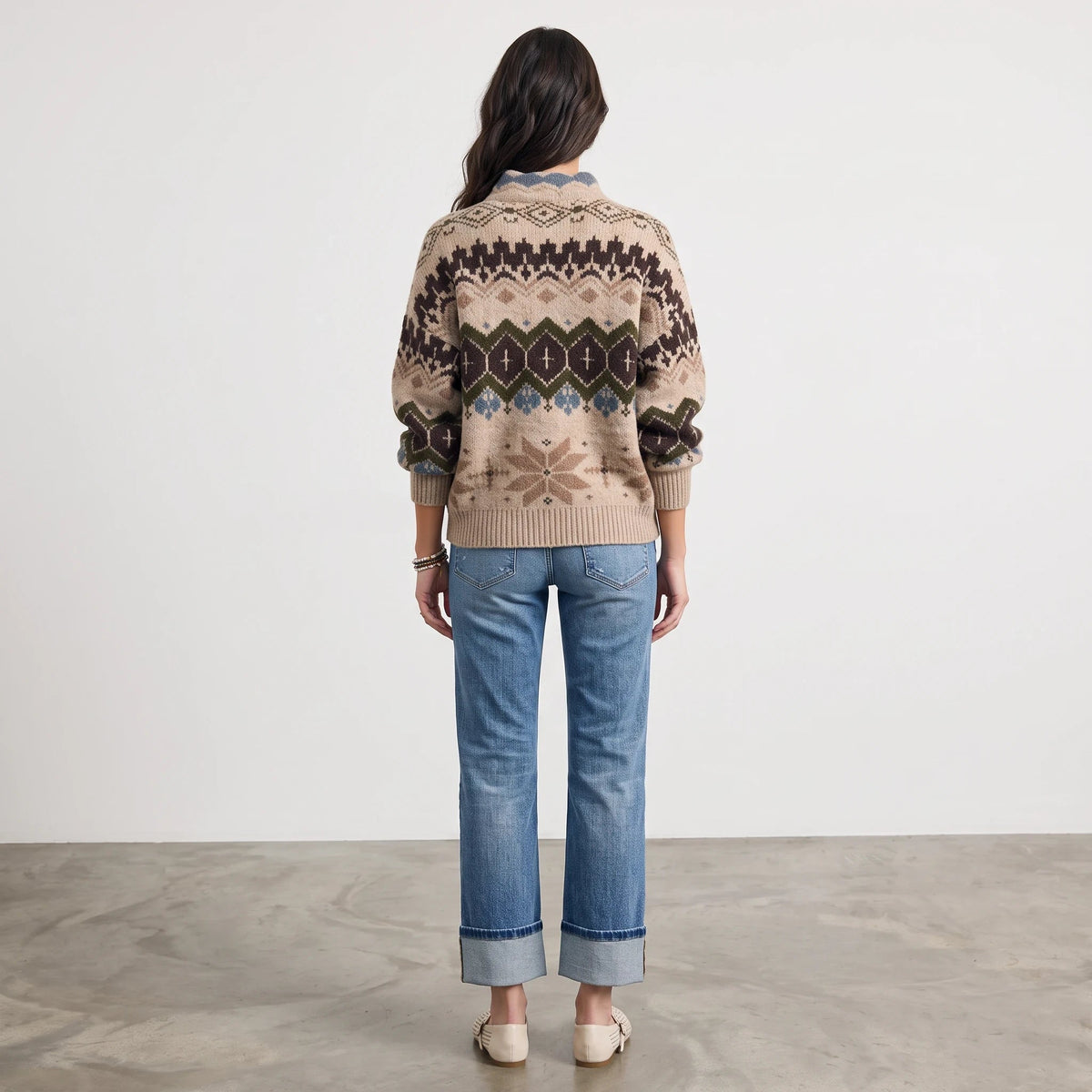 Apricot Lane Duluth Aspen Fair Isle mock neck sweater in beige with winter motifs, worn with blue cuffed jeans