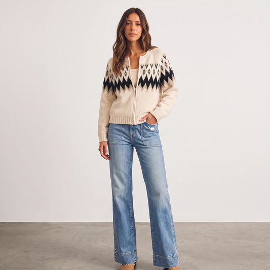 Model wearing Apricot Lane Duluth Aspen Fair Isle zip cardigan in cream and black with blue denim jeans