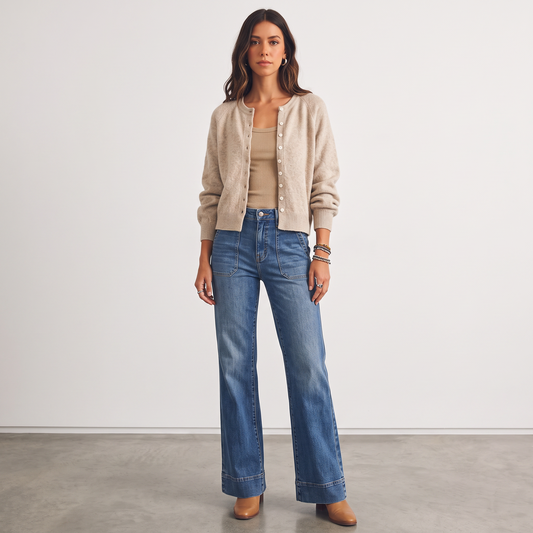 Model wearing Apricot Lane Duluth beige knit button-front cardigan with blue wide-leg jeans and tan boots