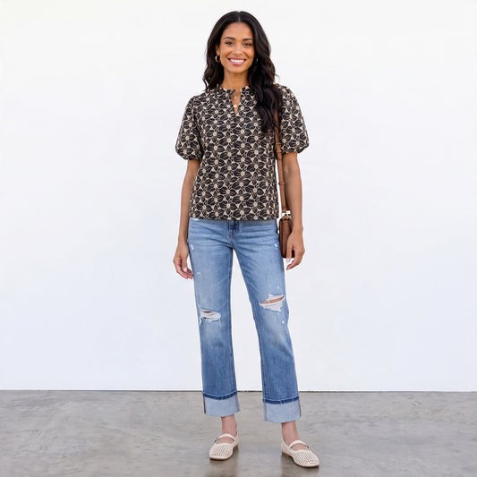 Apricot Lane Duluth model wearing a black cotton eyelet blouse with white floral embroidery, puff sleeves, and jeans.