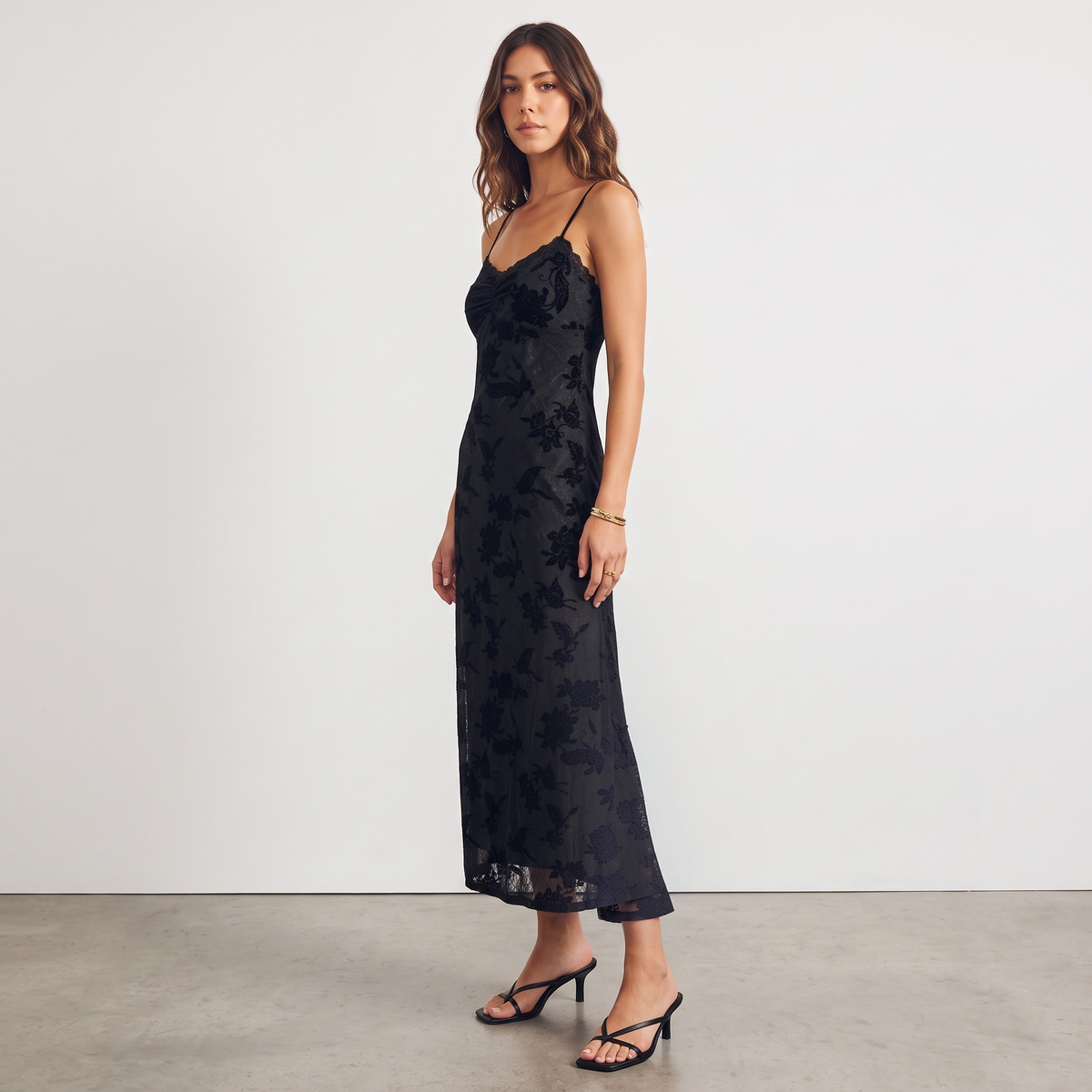 Model wearing Apricot Lane Duluth black floral velvet burnout midi slip dress with scalloped lace trim and thin straps
