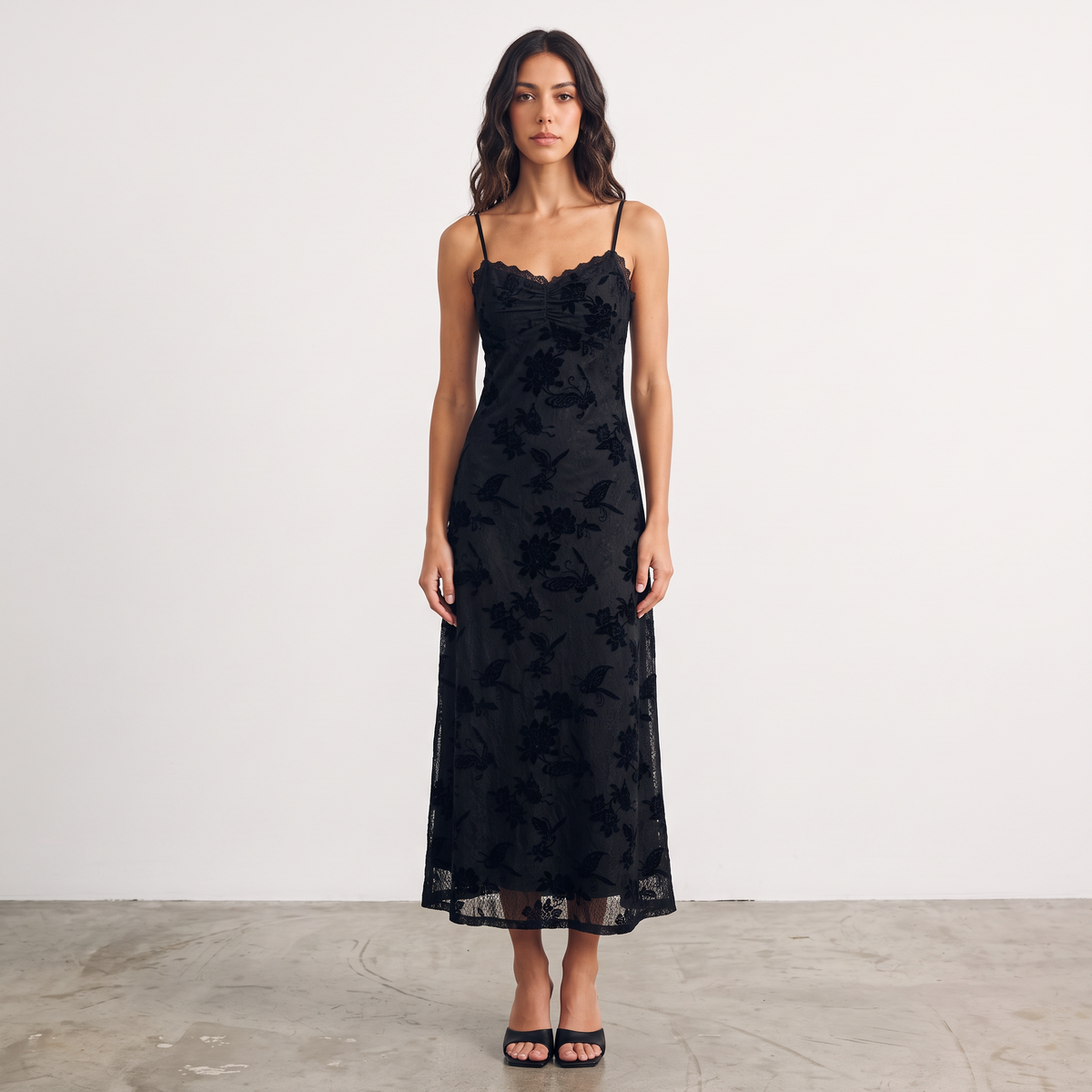 Model wearing Apricot Lane Duluth black floral velvet burnout midi slip dress with scalloped lace trim and spaghetti straps