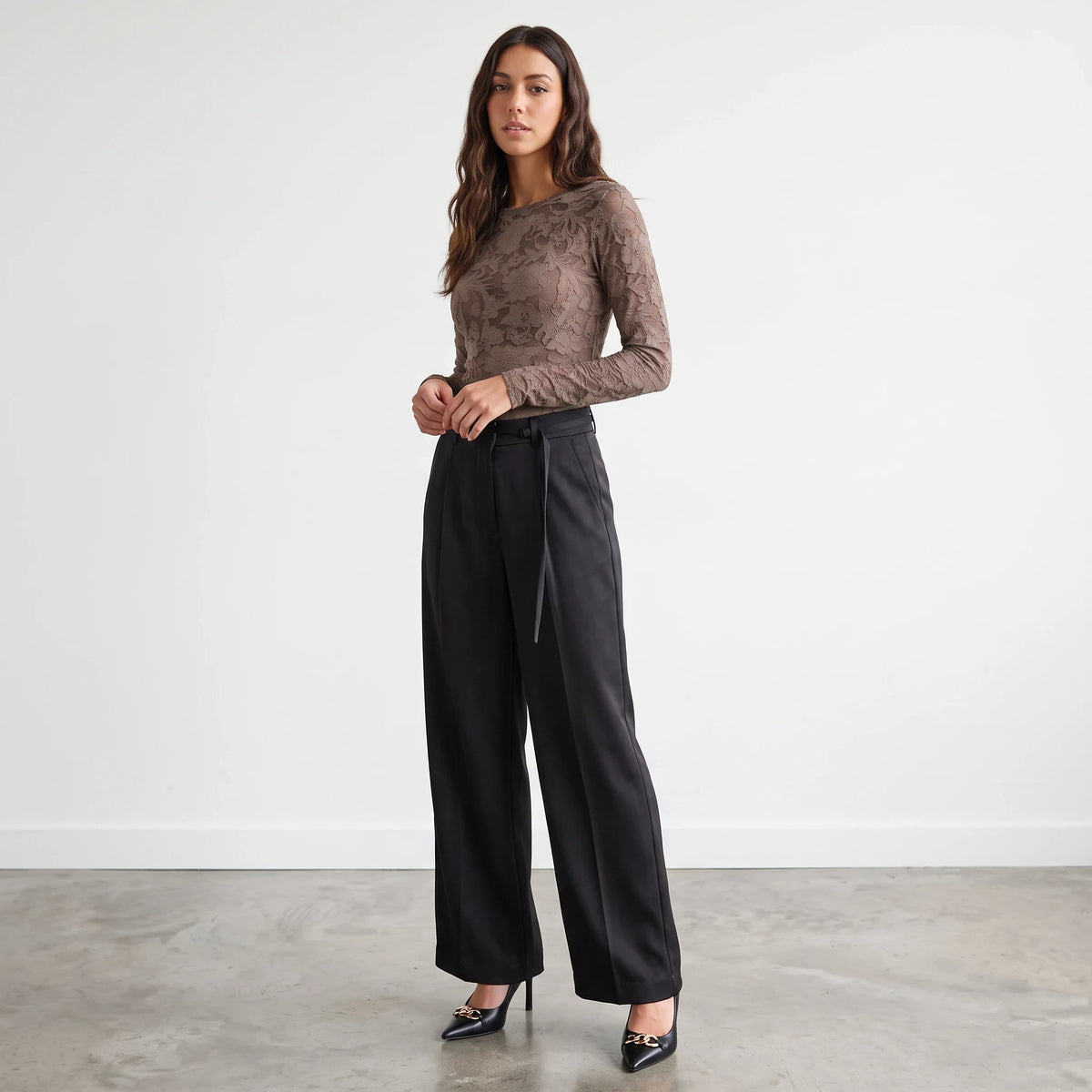 Model wearing Apricot Lane Duluth Simone satin belted black wide-leg pants with a brown lace long-sleeve top