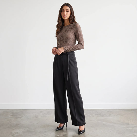 Model wearing Apricot Lane Duluth Simone satin belted black wide-leg pants with a brown lace long-sleeve top