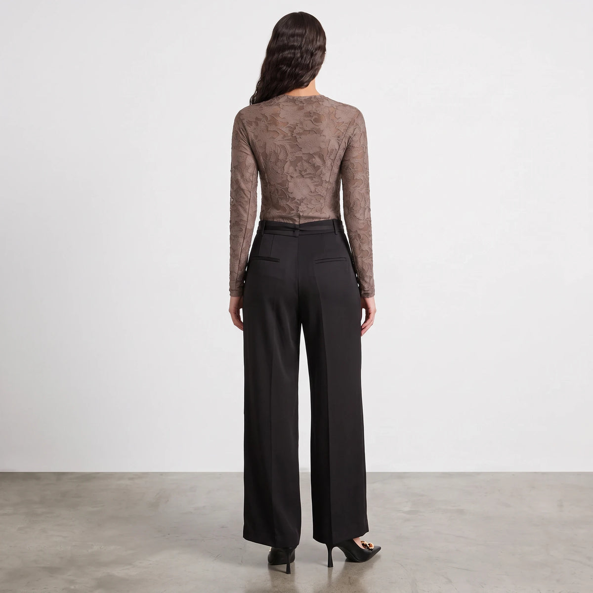 Back view of Apricot Lane Duluth Simone satin belted pants in black with a wide-leg silhouette and fluid drape.