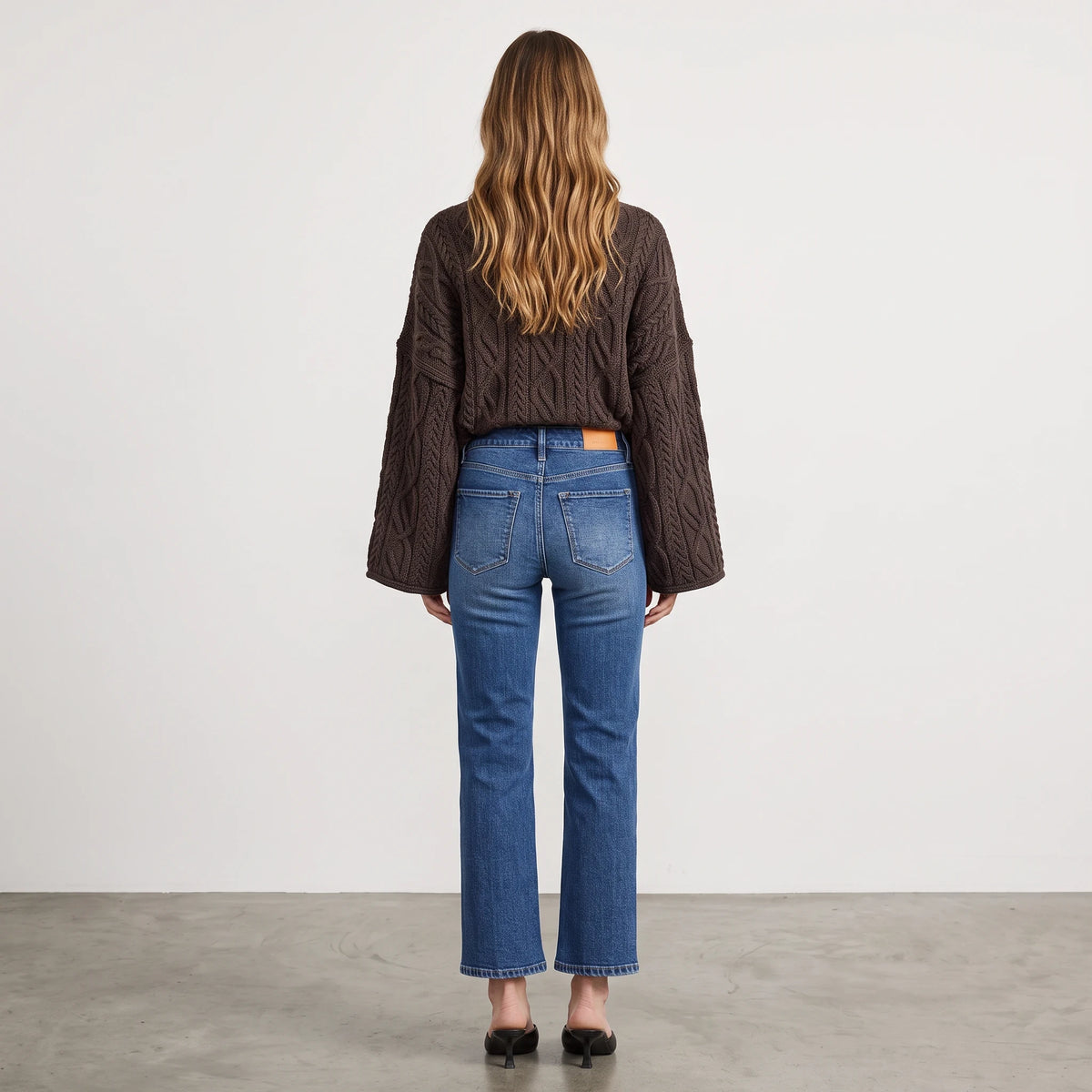 Apricot Lane Duluth oversized brown cable knit sweater with wide sleeves worn with blue denim jeans, back view