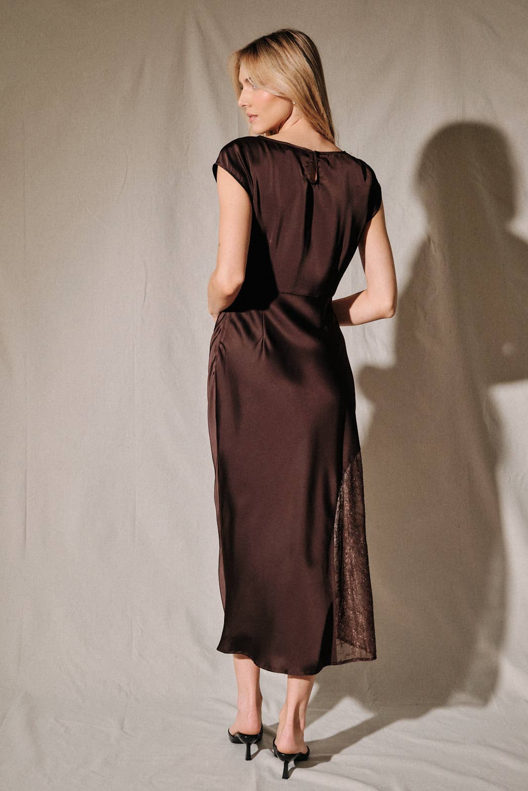 Apricot Lane Duluth brown satin midi dress with cap sleeves and lace side inserts on a model, back view