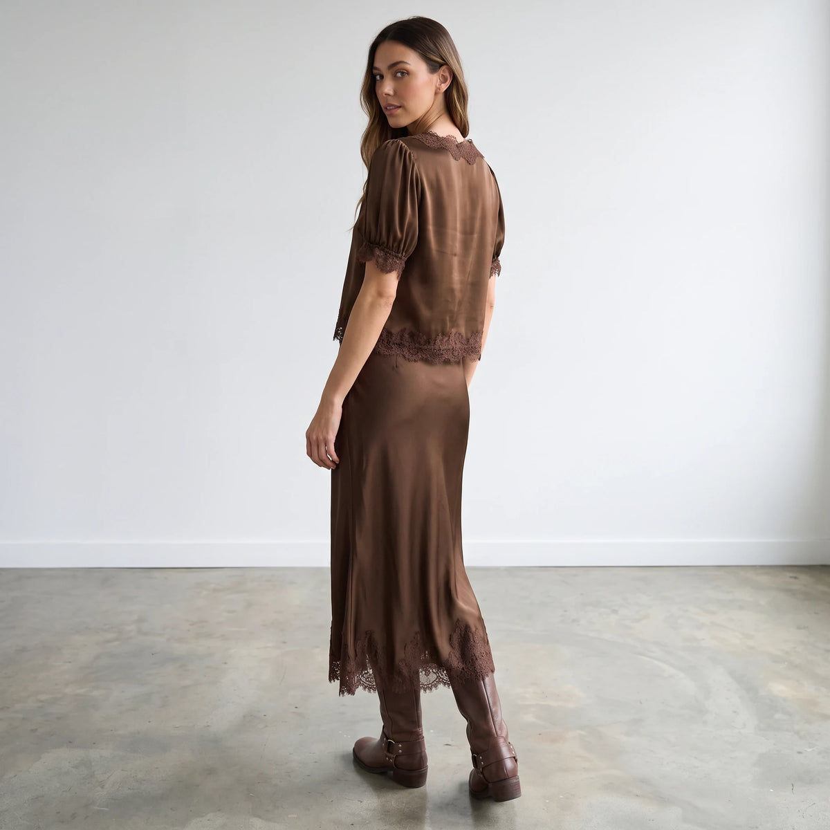 Apricot Lane Duluth model wearing a brown satin pencil skirt with lace hem and matching satin lace-trim top