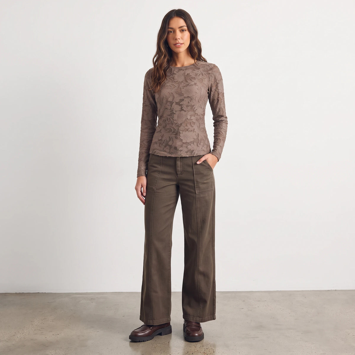 Model wearing Apricot Lane Duluth Camilla wide-leg twill pants in olive green with a brown long-sleeve lace top.