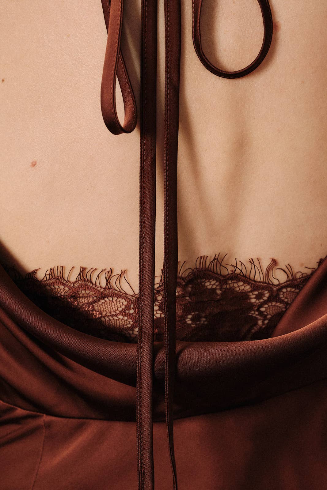 Apricot Lane Duluth chocolate brown satin slip dress featuring an open back with delicate lace trim and tie detail.