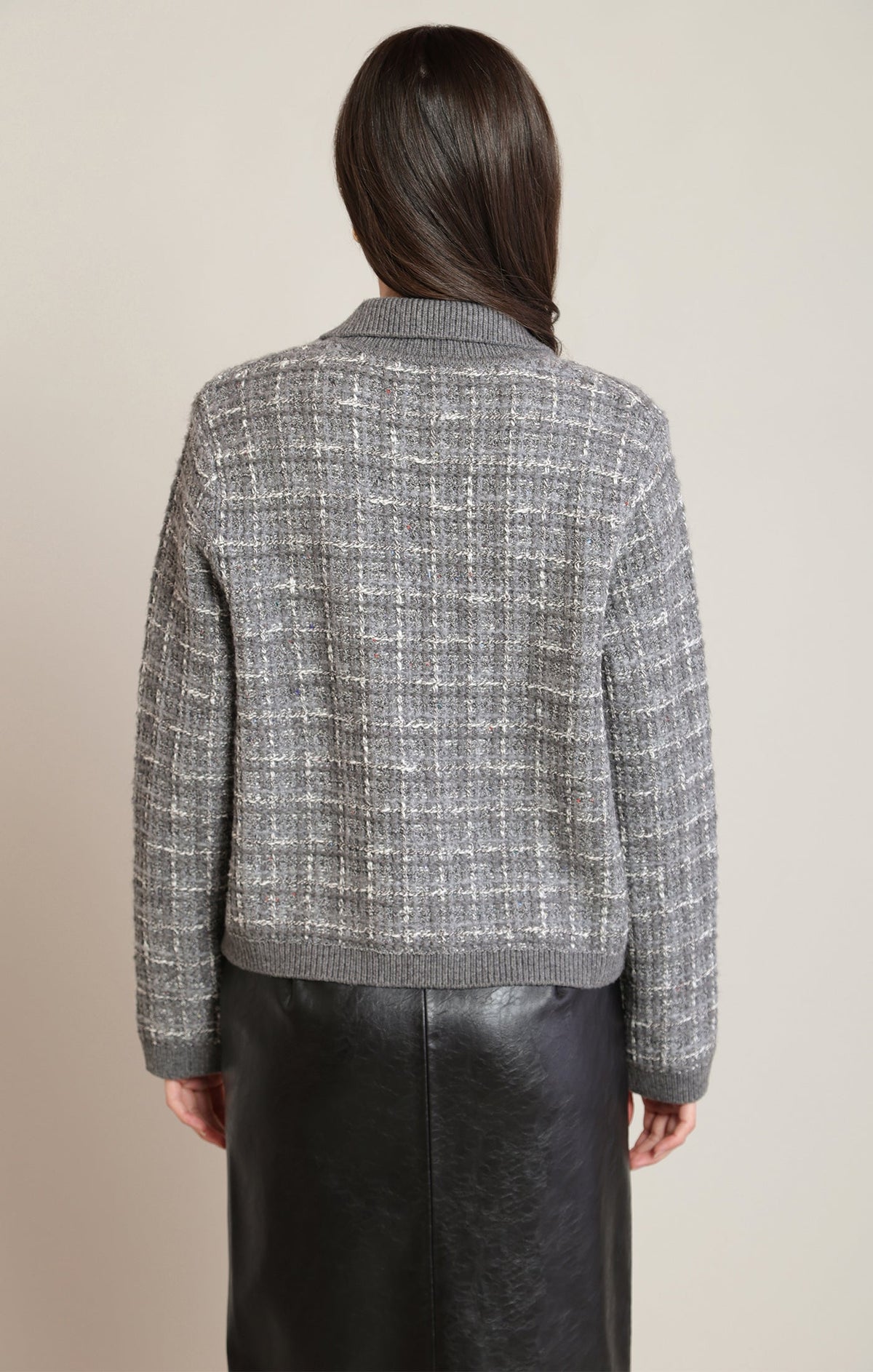 Back view of Apricot Lane Duluth Cora tweed knit cardigan in grey with ribbed trim worn over a black skirt