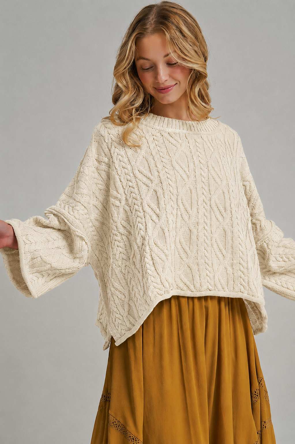 Apricot Lane Duluth oversized cream cable knit sweater with long sleeves worn by a smiling woman with blonde hair