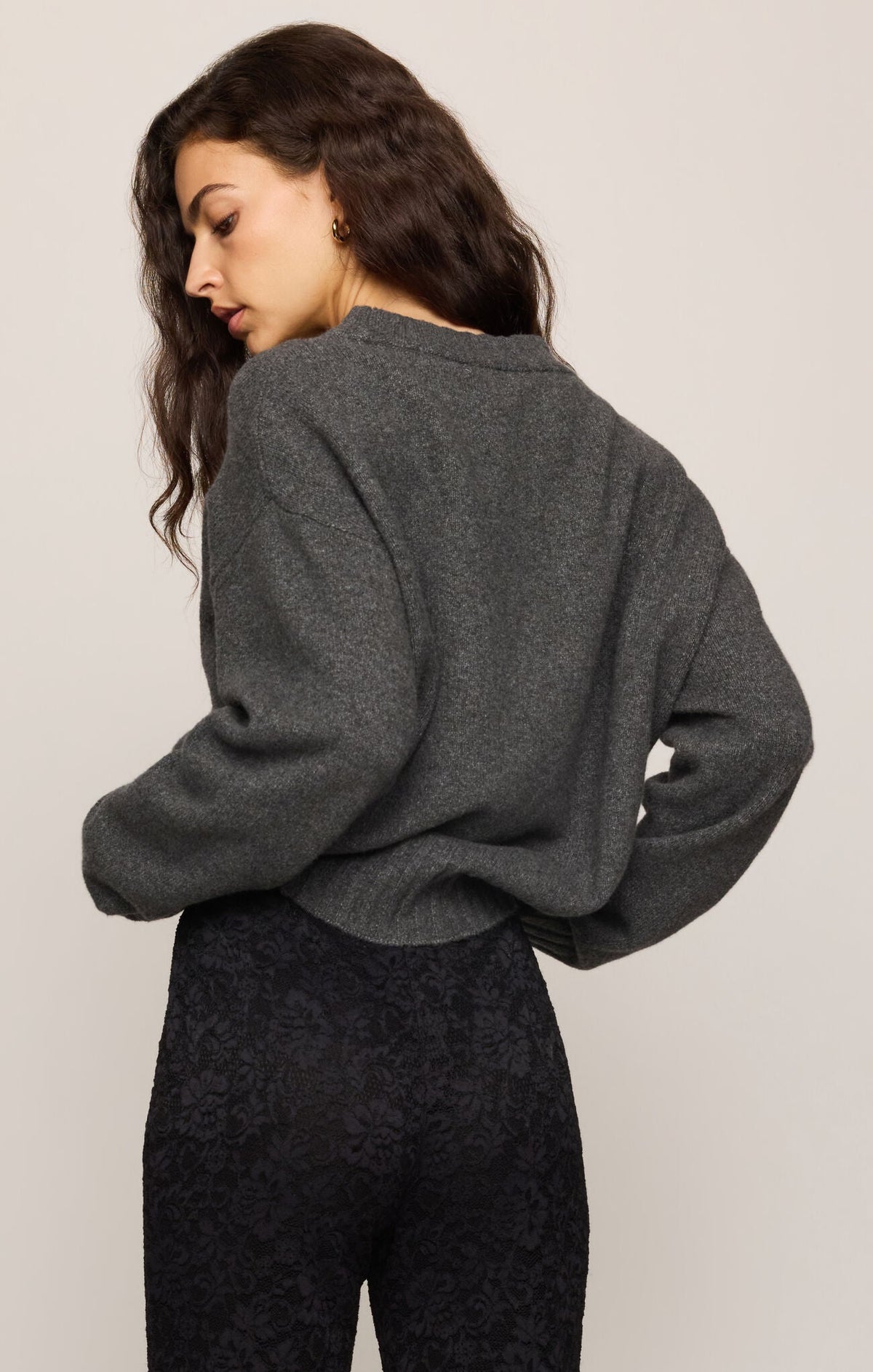 Apricot Lane Duluth Easton pullover sweater in charcoal grey worn by a woman with long dark hair, back view.