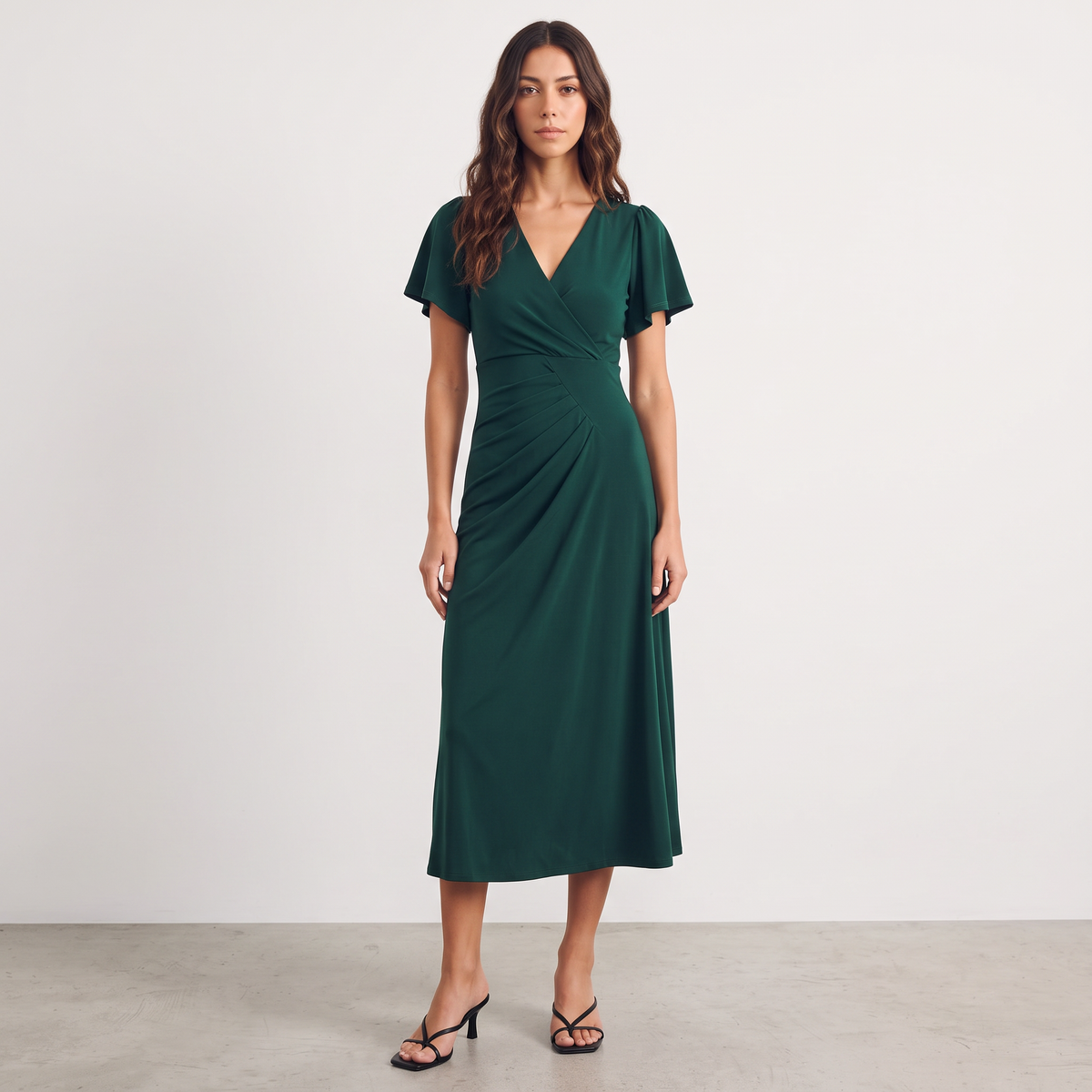 Apricot Lane Duluth Isabelle emerald green midi dress with surplice V-neck, flutter sleeves, and asymmetric pleating.