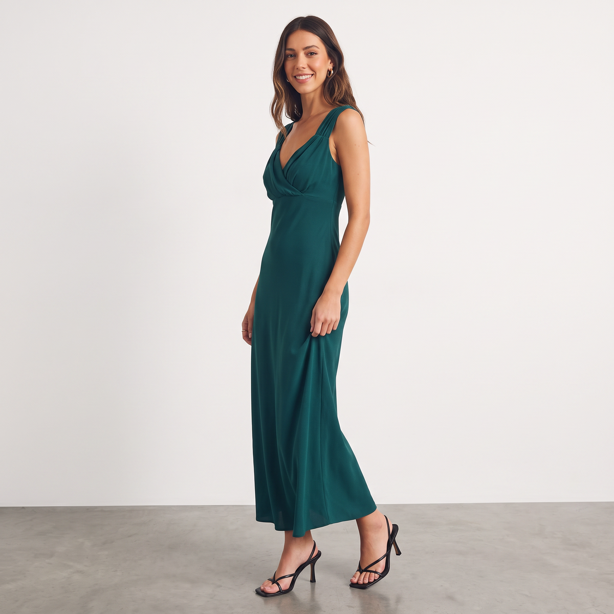 Model wearing Apricot Lane Duluth dark green sleeveless midi dress with ruched sweetheart neckline and bias-cut fit