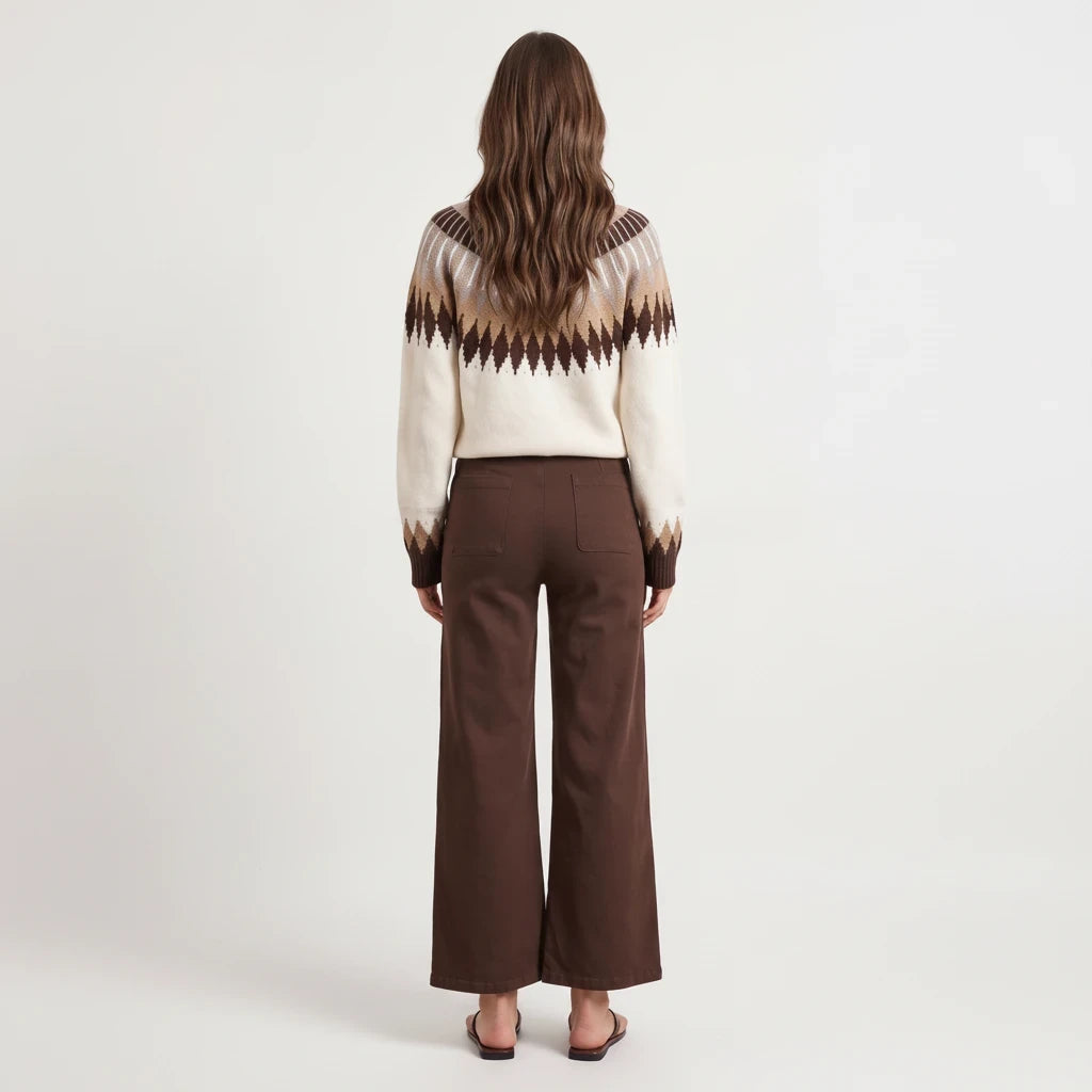 Back view of a woman wearing the Apricot Lane Duluth Brynn Fair Isle sweater with brown trousers and sandals.