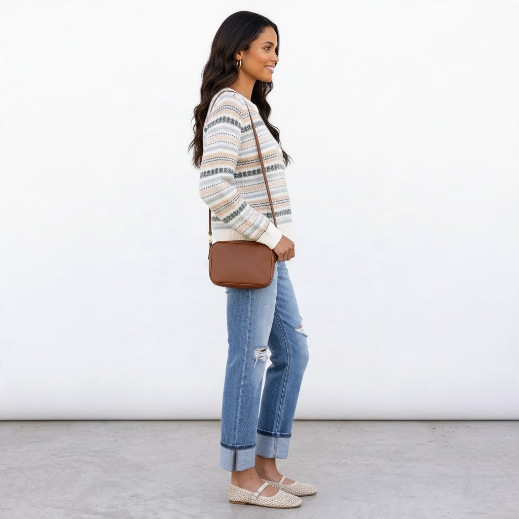 Apricot Lane Duluth Fair Isle sweater in ivory with evergreen and blue patterns, worn with jeans and a crossbody bag.