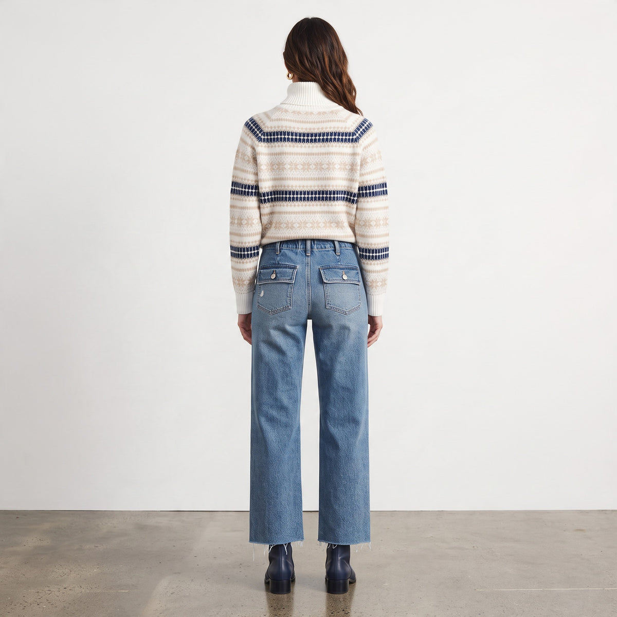 Back view of Apricot Lane Duluth ivory Fair Isle turtleneck sweater with navy and taupe patterns worn with blue jeans.