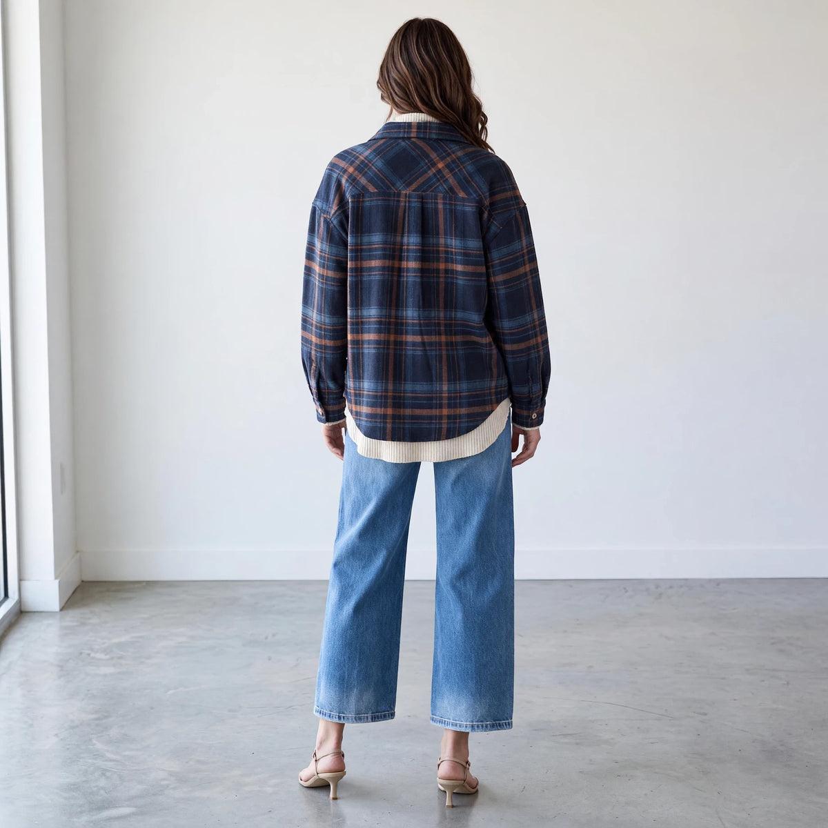 Back view of a woman wearing the Apricot Lane Duluth Fallon brushed flannel jacket in a blue and brown plaid pattern.