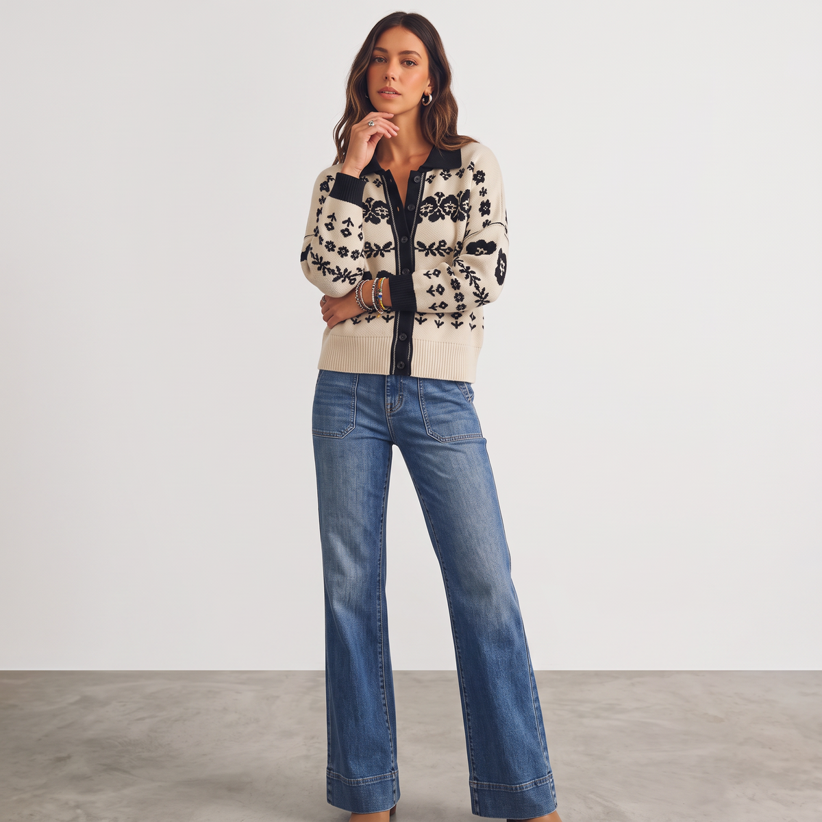 Model wearing Apricot Lane Duluth Marlowe floral jacquard cardigan with black trim and blue wide-leg denim jeans