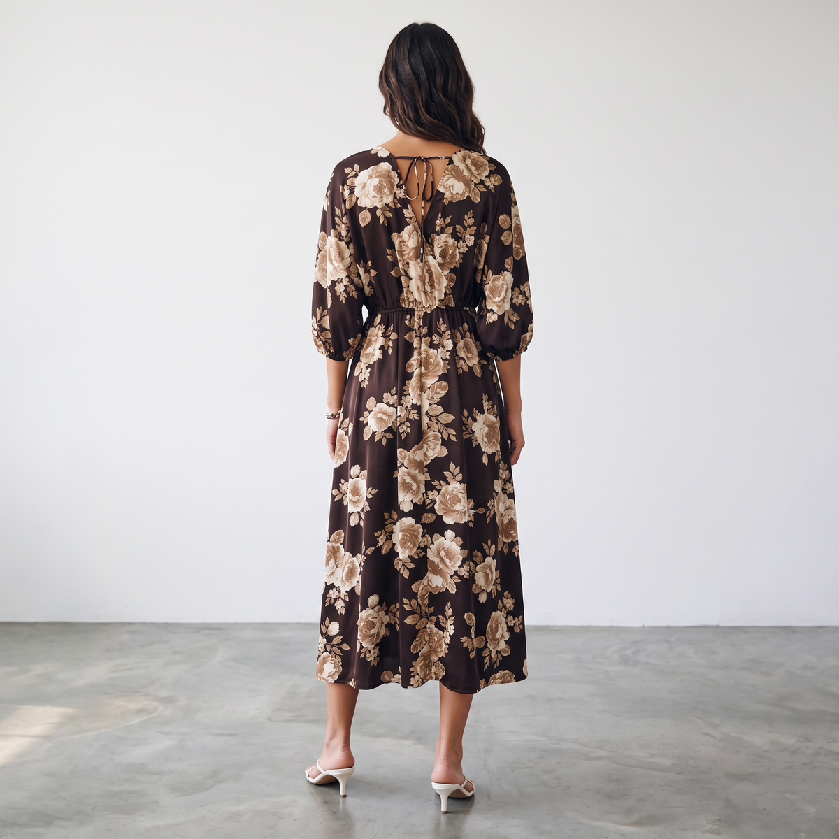 Back view of a woman wearing an Apricot Lane Duluth brown floral midi dress with kimono sleeves and a tie-back detail.