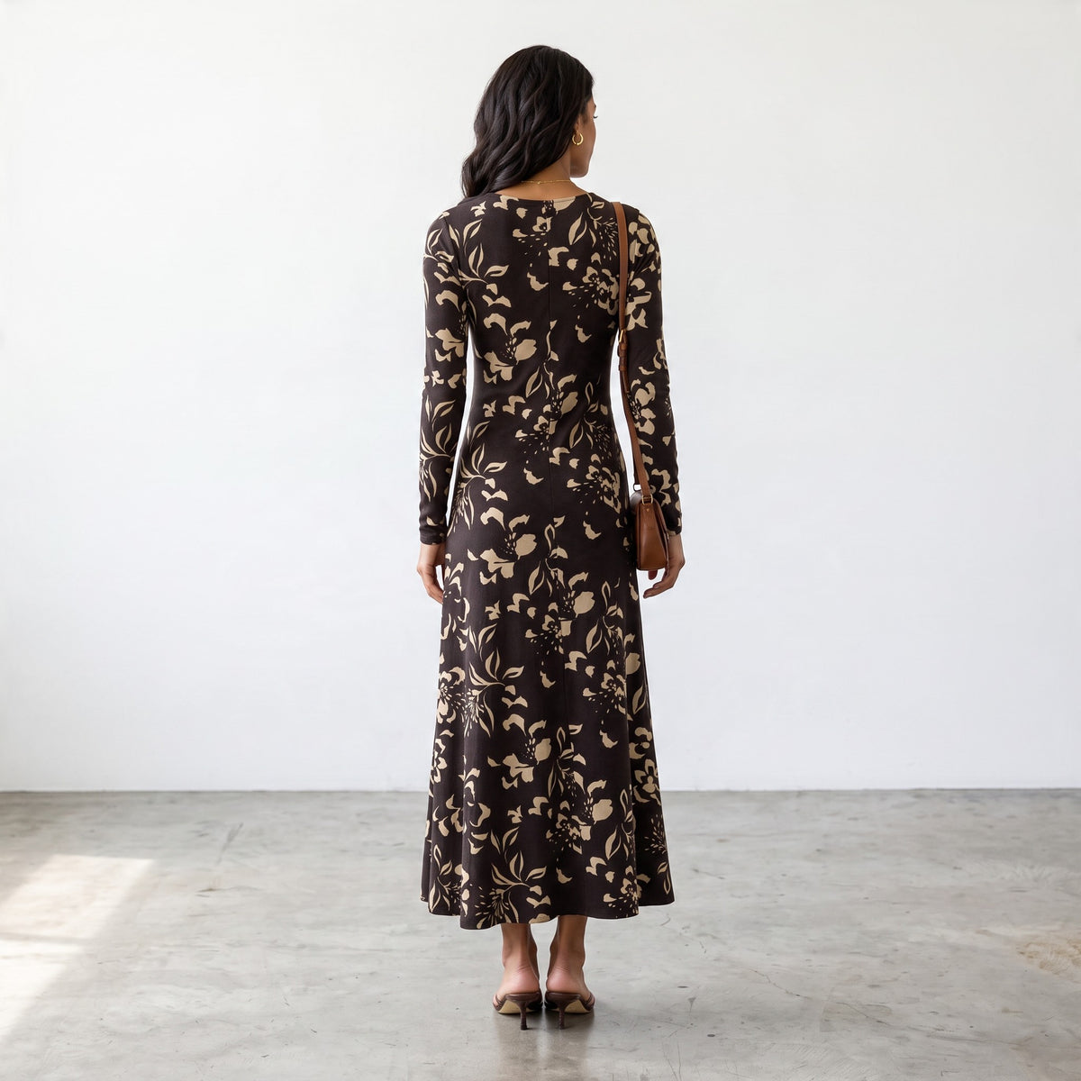 Back view of a woman wearing an Apricot Lane Duluth floral midi dress in brown stretch jersey with long sleeves.