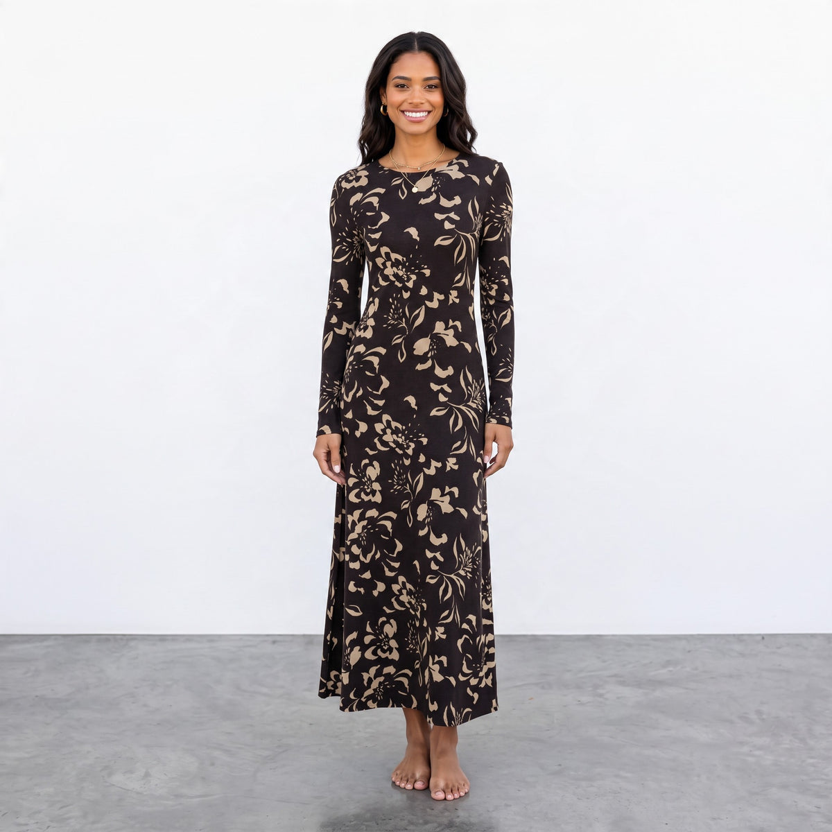 Model wearing an Apricot Lane Duluth long-sleeve midi dress in black with a beige floral print and boat neckline.