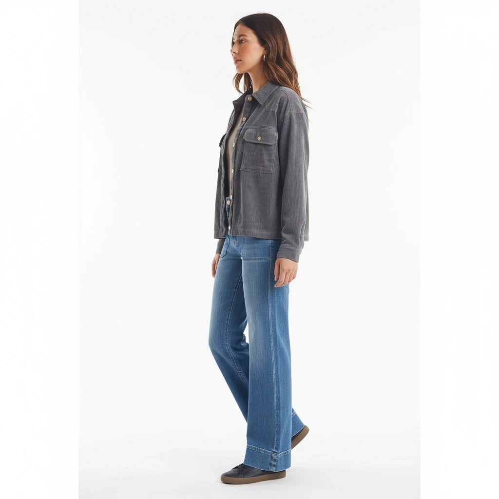 Model wearing Apricot Lane Duluth Hadley oversized grey corduroy shacket with blue jeans and sneakers, side view