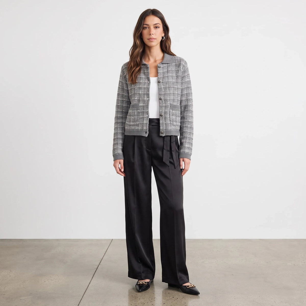 Model wearing Apricot Lane Duluth Cora tweed knit cardigan in grey with black trousers and pointed flats