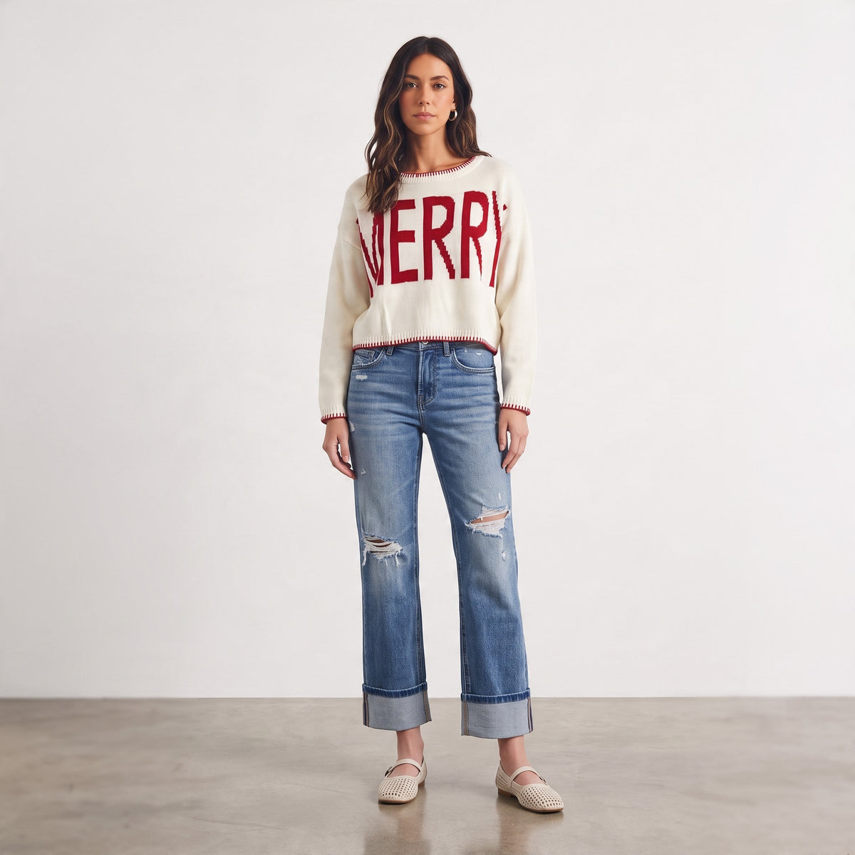 Apricot Lane Duluth cream knit sweater with red MERRY graphic and contrast trim worn with distressed blue jeans