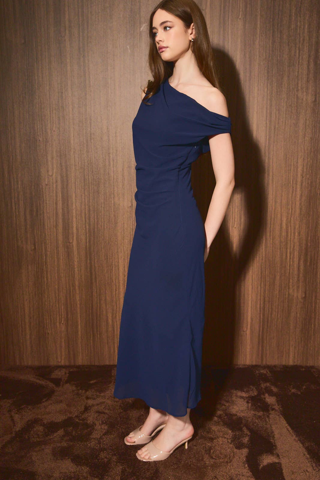 Model wearing Apricot Lane Duluth navy one-shoulder midi dress in crepe fabric with a sleek body-skimming silhouette.
