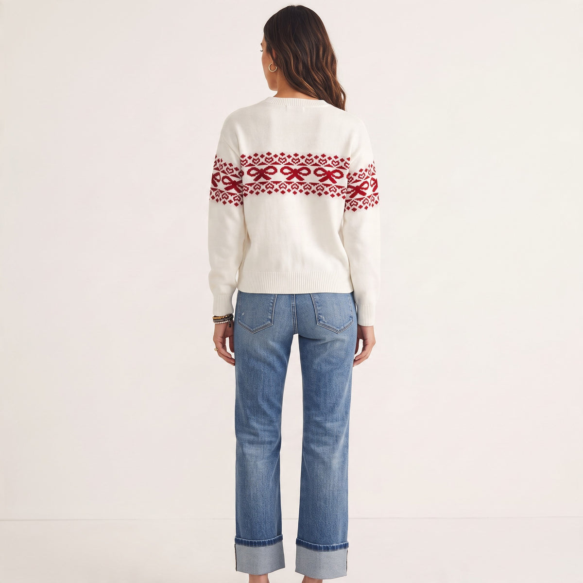 Apricot Lane Duluth white sweater with red bow and heart Fair Isle pattern worn with blue jeans, back view