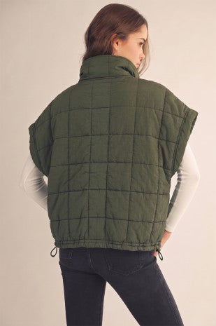 Model wearing an olive green Apricot Lane Duluth puffer pullover vest with a quilted design and side slits