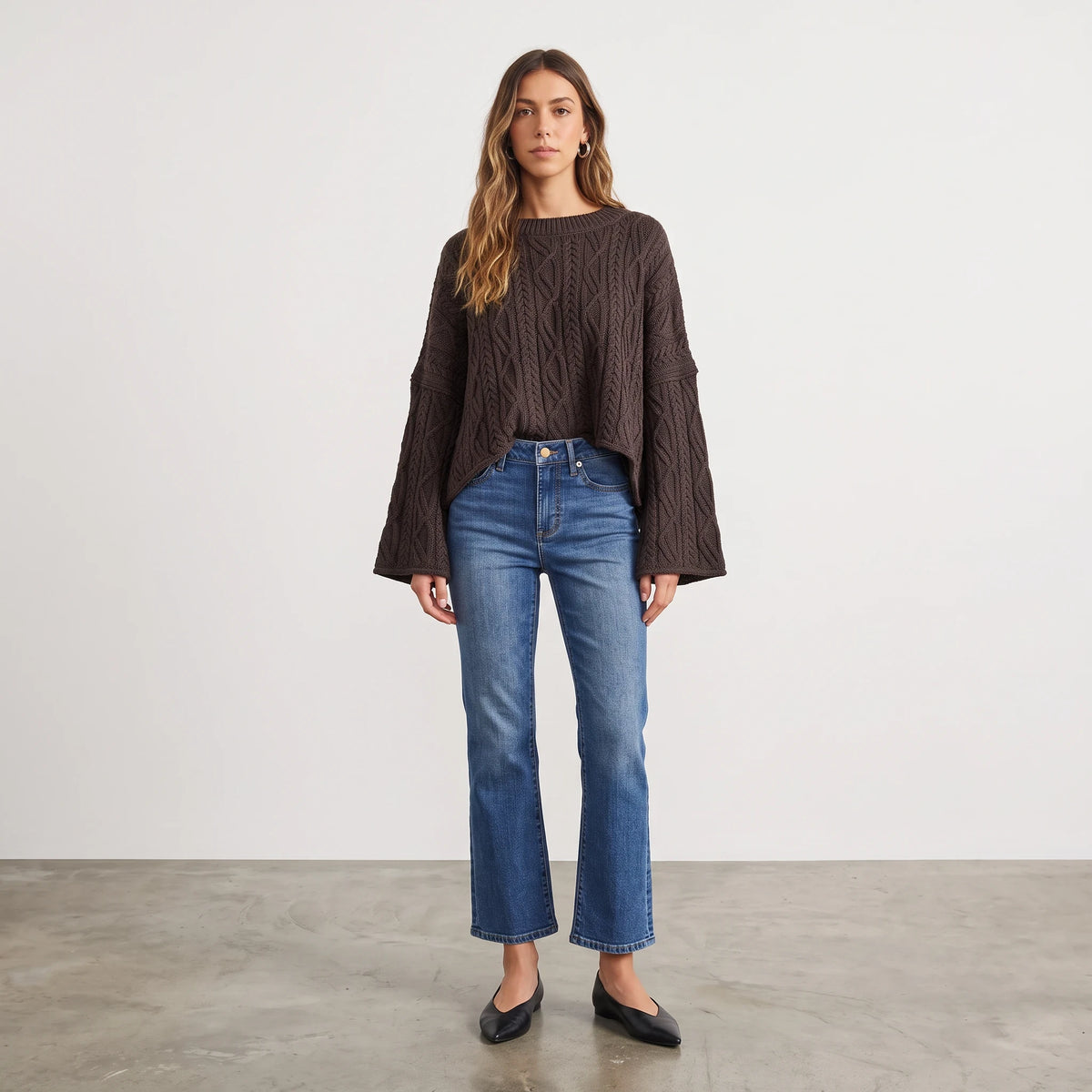 Apricot Lane Duluth oversized dark brown cable knit sweater with wide sleeves worn with blue jeans and black flats.