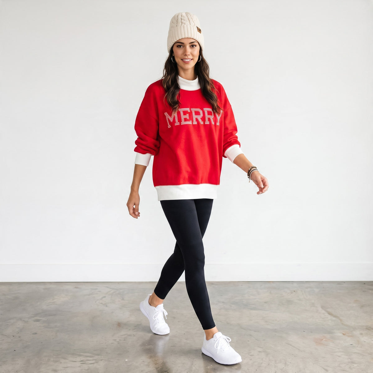 Apricot Lane Duluth red oversized mock neck Christmas top with MERRY text, worn with leggings and a knit beanie