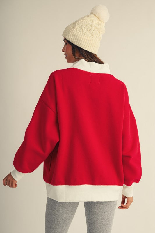 Apricot Lane Duluth oversized red Christmas top with white mock neck and ribbed trim worn with a matching beanie