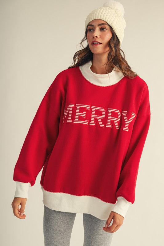 Apricot Lane Duluth red oversized mock neck Christmas top with white Merry graphic and ribbed trim worn by a model