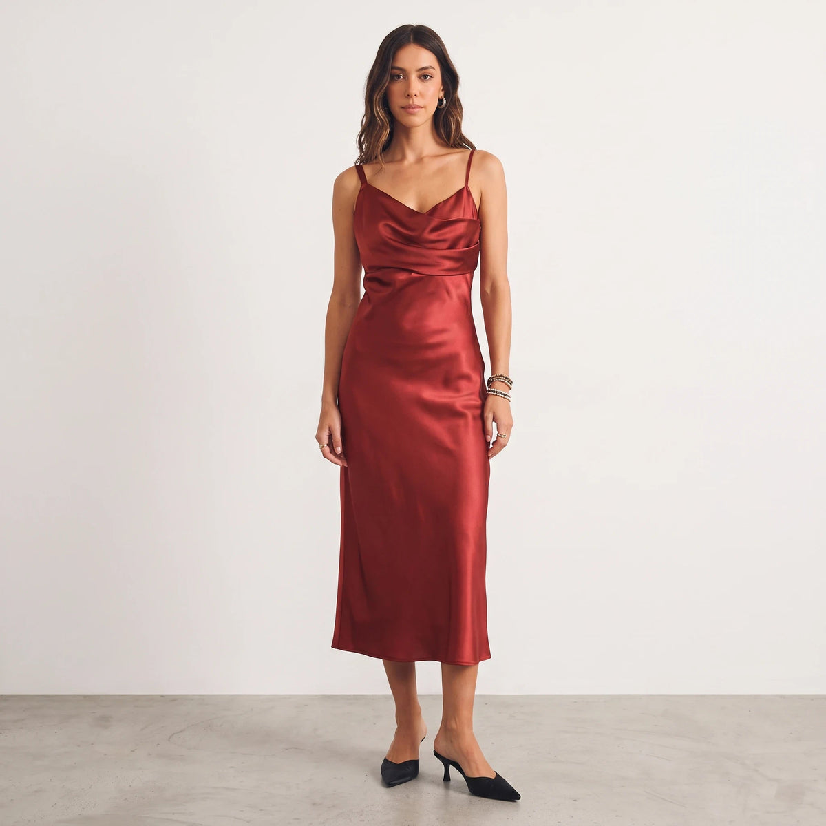Model wearing Apricot Lane Duluth red satin midi dress with asymmetrical cowl neckline and cami straps