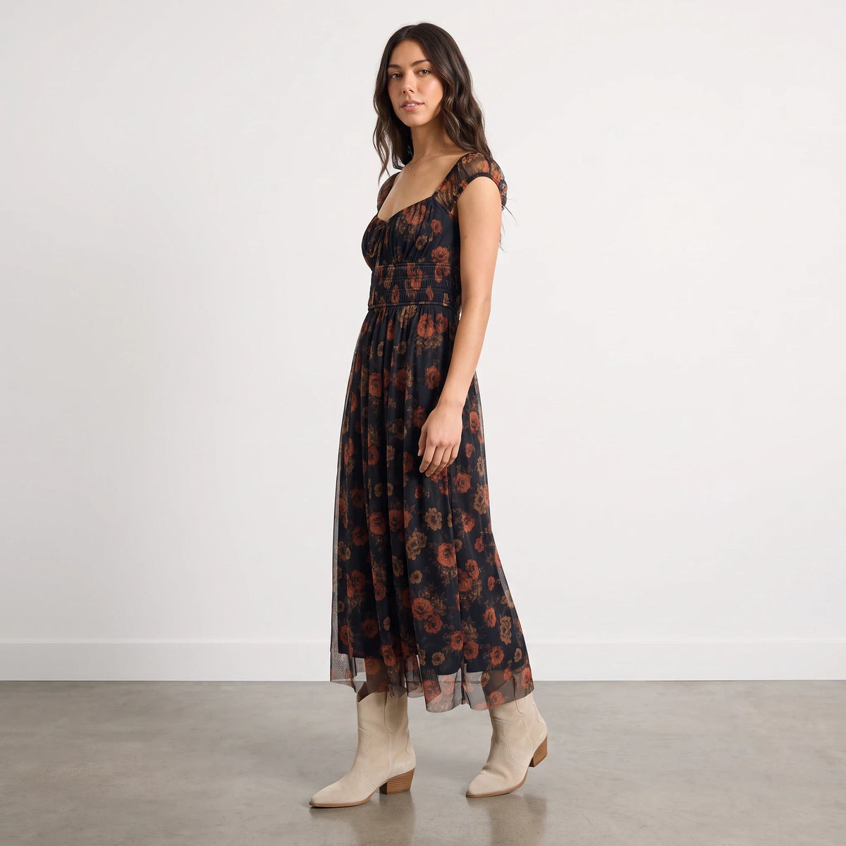 Model wearing Apricot Lane Duluth Rosalie floral organza midi dress with sweetheart neckline and beige western boots